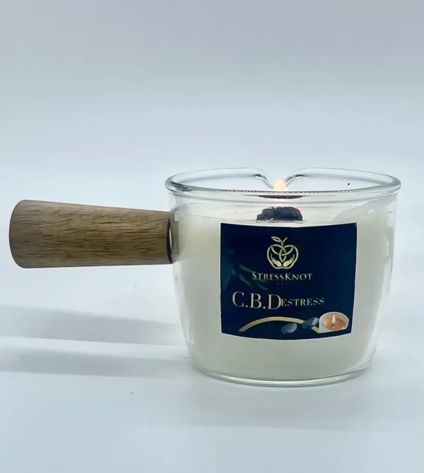 Stress Knot NYC C.B.Destress massage candle with wooden handle for soothing aromatherapy and pain relief treatments.