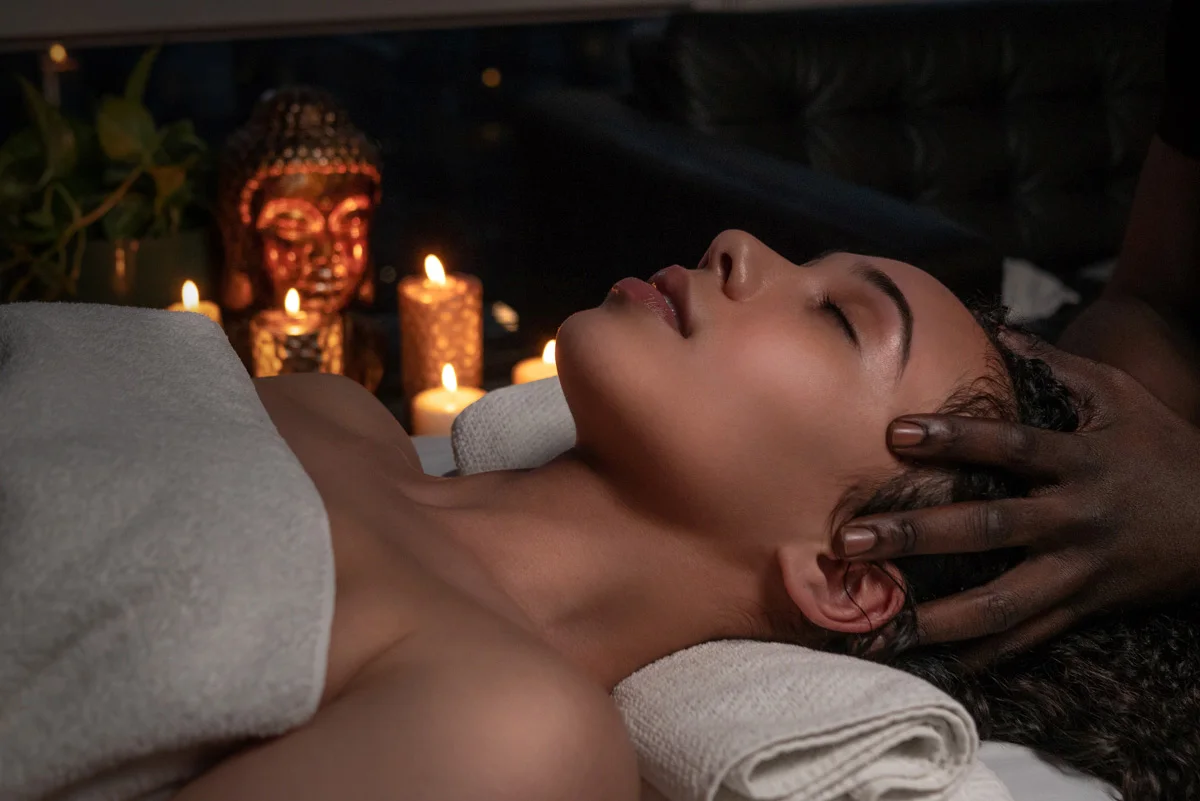 Relaxing in-home massage in NYC with aromatherapy candles and professional therapist creating a calming spa atmosphere.